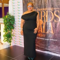 Host posing at an awards gala backdrop
