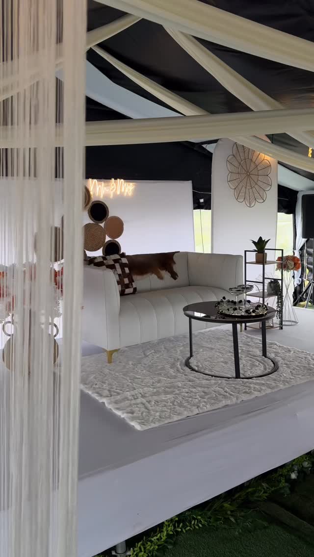 Luxury white lounge tent setup with crystal curtains and neon Mr & Mrs sign